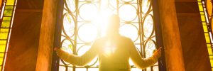 Religious woman in a church looking at the light shining through a stained glass window