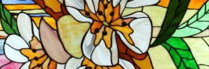 Stained glass window featuring a design of white and orange flowers